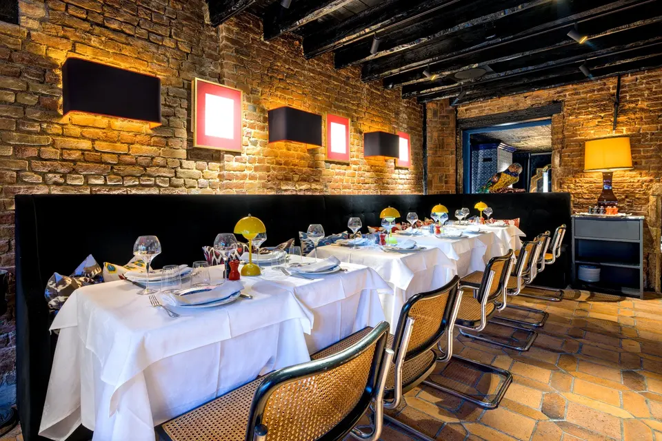 Grande table dressée pour un dîner privé dans la salle de briques du Corbier