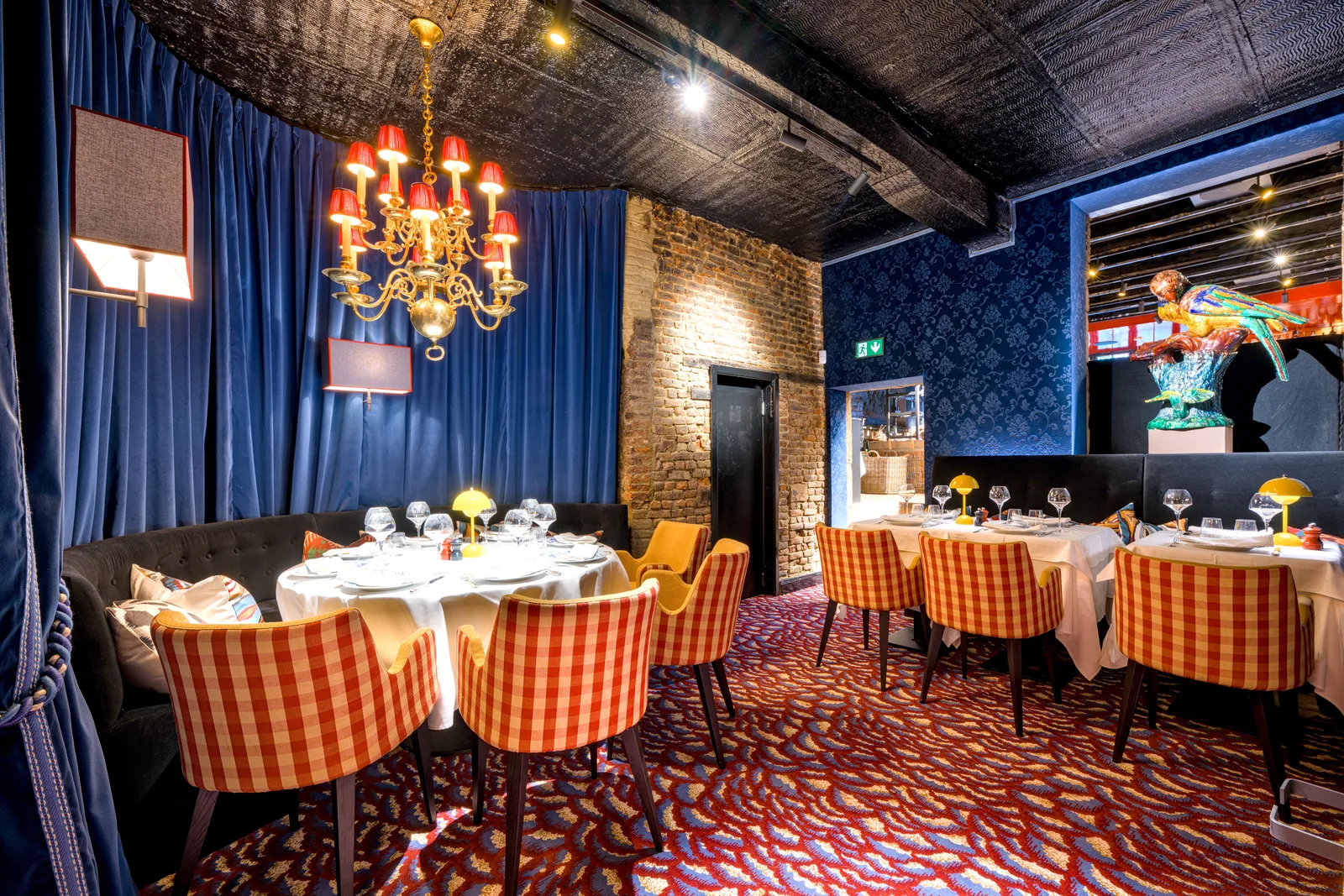 Salle du Corbier avec ses fauteuils à carreaux et son lustre
